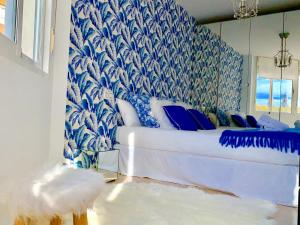 1 dormitorio con 1 cama con papel pintado azul y blanco en Málaga Center Beach, en Málaga