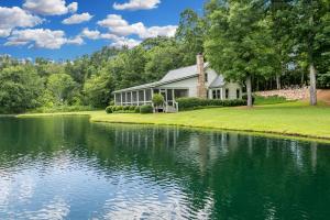a house with a lake in front of it at The Estate in Eatonton 