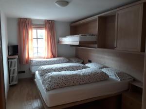 3 Betten in einem Zimmer mit Fenster in der Unterkunft Chalet Del Sole per gruppi in Livigno