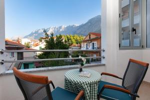 un patio con tavolo e sedie sul balcone. di Guest House Damir a Makarska