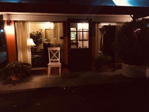 a white chair sitting outside of a house at night at Cheshire Motor Inn in Atlanta