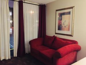 a red couch in a room with a window at Cheshire Motor Inn in Atlanta