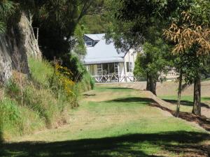 a house in the middle of a field with trees at Grandeur Thermal Spa Resort in Taupo
