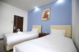 two beds in a room with blue walls at SABUN-NGA HOSTEL in Chiang Rai