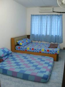 a bedroom with two twin beds and a window at Yong Homestay in Kuala Perlis