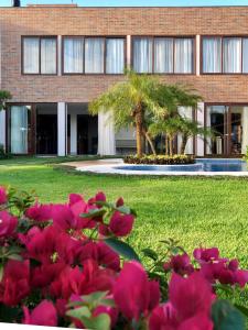 un edificio con flores rosas delante de él en Jardim do Rio Suítes, en Florianópolis