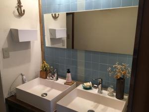 a bathroom with a white sink and a mirror at Guest House Minato in Miyako