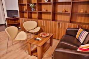 a living room with a couch and a table and shelves at Dream Residence splai in Bucharest