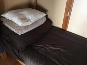 a bed with two pillows on top of it at Guest House Minato in Miyako