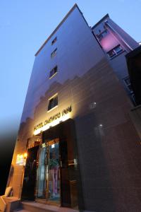 un bâtiment avec un panneau sur son côté dans l'établissement Hotel Daewoo Inn, à Séoul