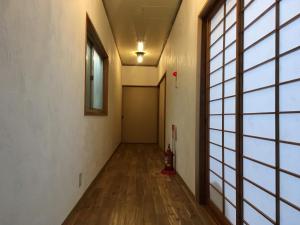 an empty hallway with a large window and wooden floors at Guest House Minato in Miyako