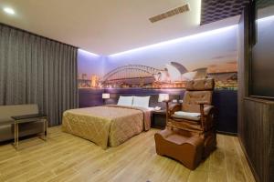 una camera d'albergo con letto e sedia di Foxdou Business Motel a Tainan