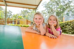 two little girls sitting on top of a picnic table at NRMA South West Rocks Holiday Park in South West Rocks