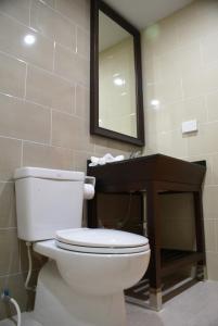 a bathroom with a toilet and a sink and a mirror at Panya Resort Hotel in Udon Thani