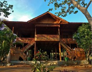 a house with a wooden roof and wooden stairs at Nirwana Buton Villa in Baubau +30 photos