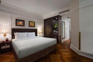 a bedroom with a large white bed and wooden floors at Silk Path Boutique Hanoi in Hanoi