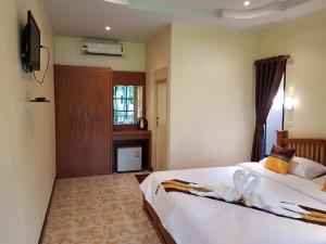 a hotel room with two beds and a television at Naraya Resort in Ko Lanta