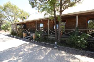 una casa de madera con árboles delante de ella en Silverpoint Estate en Pokolbin