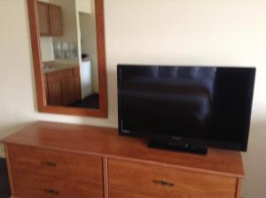 TV en la parte superior de un tocador con espejo en Best Inn & Suites, en Anaheim