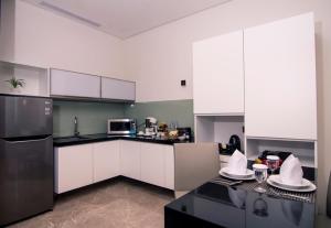 a kitchen with a refrigerator, stove, sink and microwave at PSW Antasari Hotel in Jakarta