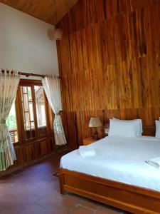 a bedroom with a large bed with wooden walls at Free Beach Resort in Phú Quốc