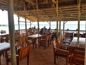 a restaurant on the beach with tables and chairs at Free Beach Resort in Phú Quốc