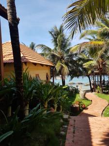 a house on the beach with palm trees and a walkway at Free Beach Resort in Phu Quoc