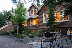 a house with two chairs and a table in front of it at Banff Boutique Inn - Adults only in Banff