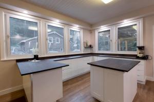 a large kitchen with white cabinets and windows at Banff Boutique Inn - Adults only in Banff