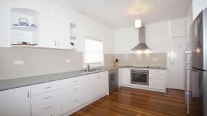 a kitchen with white cabinets and a stainless steel refrigerator at My Blue Heaven - Dog Friendly in Lennox Head
