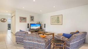 a living room with two couches and a tv at Moana Retreat in Lennox Head