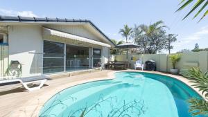 a swimming pool in front of a house at Barefoot in Lennox- Beachfront Pool in Lennox Head