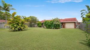 a yard with a fence and a house at Alexander Palms in East Ballina