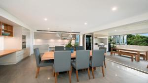 a kitchen and dining room with a wooden table and chairs at Vista in Lennox Head
