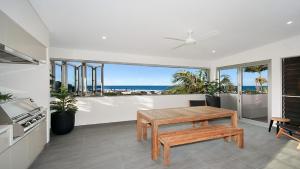 a dining room with a table and a view of the ocean at Vista in Lennox Head
