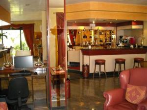 a room with a bar with stools and a counter at Hotel La Corte in Rubiera