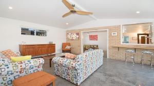 a living room with two couches and a ceiling fan at Betty's in Lennox Head