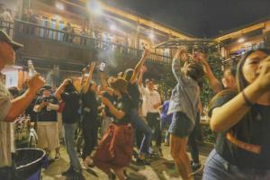 grupa ludzi tańczących na imprezie w obiekcie Lijiang Desti Youth Park Hostel w mieście Lijiang