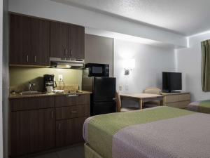 a hotel room with two beds and a kitchen at Studio 6-Miamisburg, OH - Dayton in Miamisburg