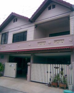 una casa con una cerca blanca delante de ella en Chomhaad Guesthouse, en Hua Hin