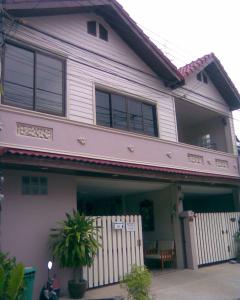 a house with a white fence in front of it at Chomhaad Guesthouse in Hua Hin