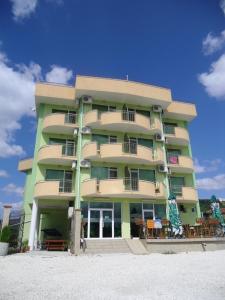 a tall building on the beach next to the sand at Anelia Family Hotel in Kavarna