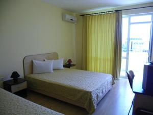 a hotel room with a bed and a sliding glass door at Anelia Family Hotel in Kavarna +33 photos
