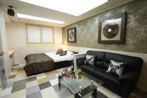 a living room with a bed and a couch at Restay Kokura (Adult Only) in Kitakyushu