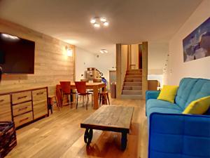 a living room with a blue couch and a table at La Durance in Montgenèvre