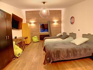 a bedroom with two beds and a table and a dining room at La Durance in Montgenèvre