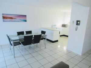 - une cuisine avec une table et des chaises dans la chambre dans l'établissement The Shores Holiday Apartments, à Mackay