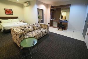 a hotel room with a couch and a bed at S Boutique Hotel in Ipoh