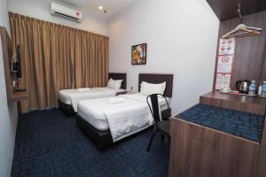 a hotel room with two beds and a desk at S Boutique Hotel in Ipoh