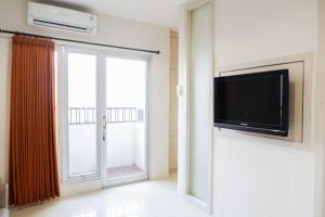 Televisyen dan/atau pusat hiburan di Comfy 1BR Twin Tower Apartment By Travelio +6 gambar